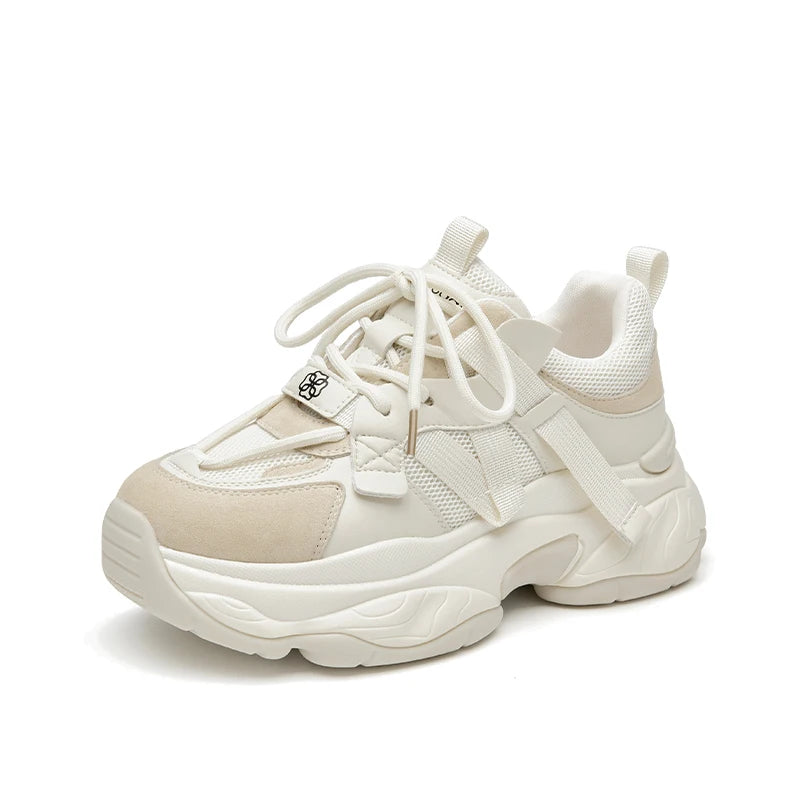 Beige sneaker with white laces on a light beige background