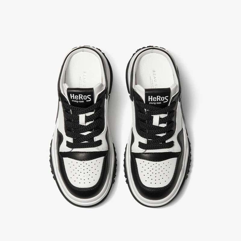 Black and white sneakers with 'Heros' branding on a light gray background