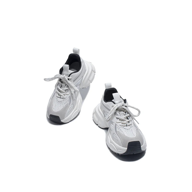 Pair of white sneakers with black soles on a white background
