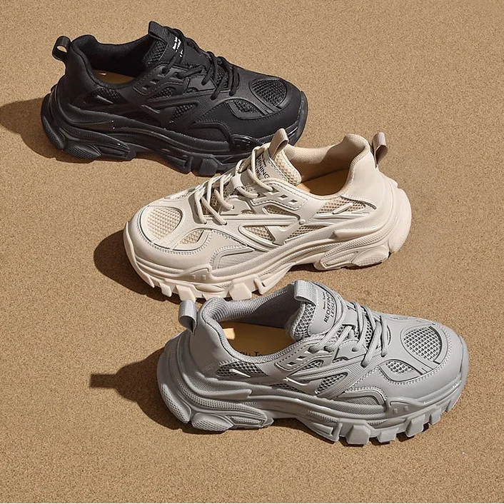 Three sneakers in black, white, and gray on a beige background 