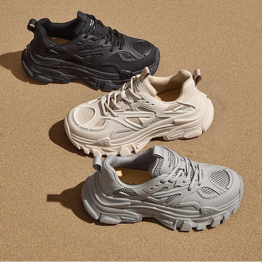 Three sneakers in black, white, and gray on a beige background 