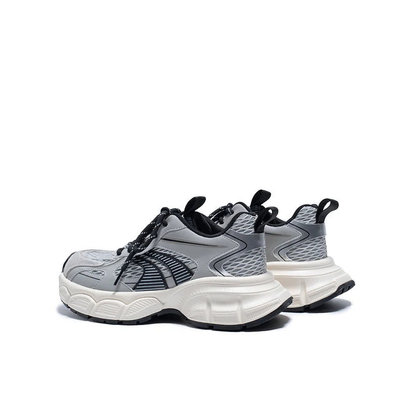 Gray and black sneakers with white soles on a white background
