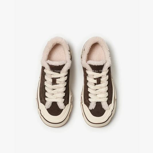 Pair of brown sneakers with white laces and fur-lined tops on a light gray background